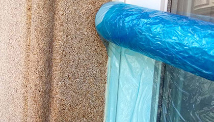 Colocación de plástico protector Proteplas en ventanas para hidrofugar fachada